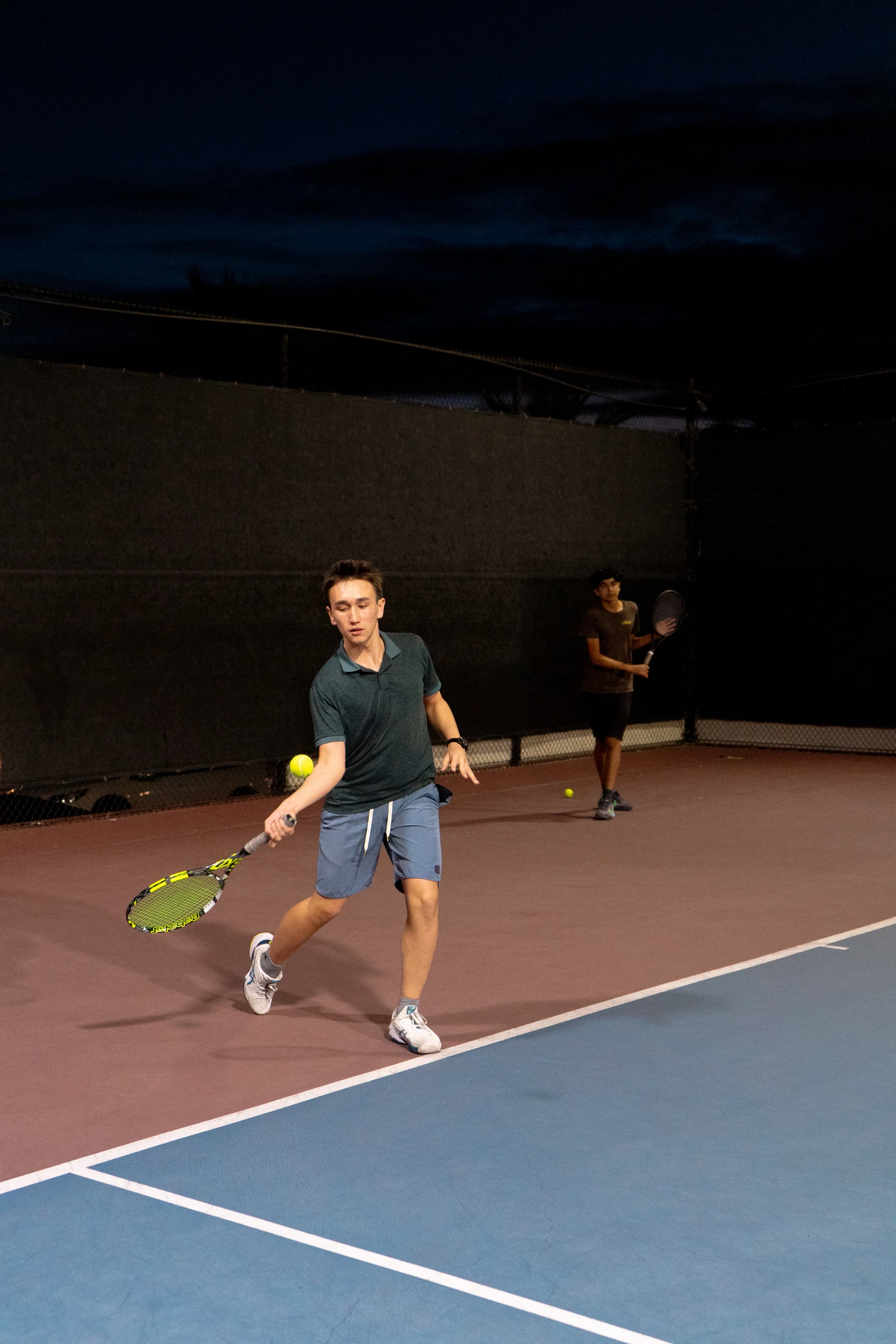 Night practice — forehand swing under court lights