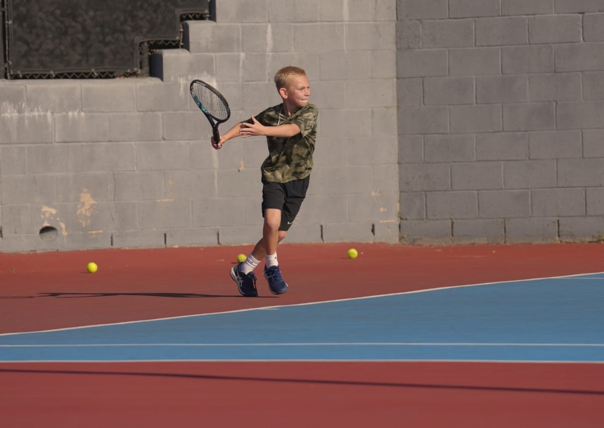 Competitive Green Dot player running drills on blue hard court