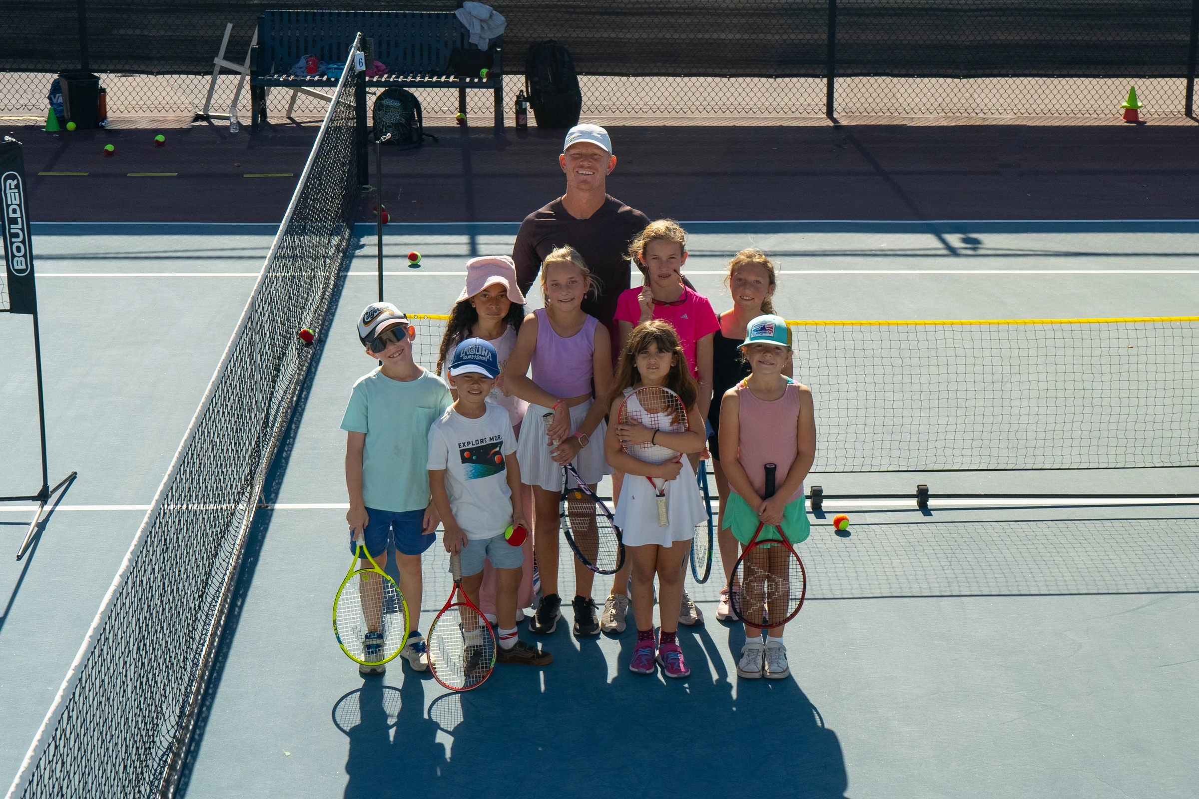 Junior campers and coaches on court during LBTA holiday and summer tennis camps