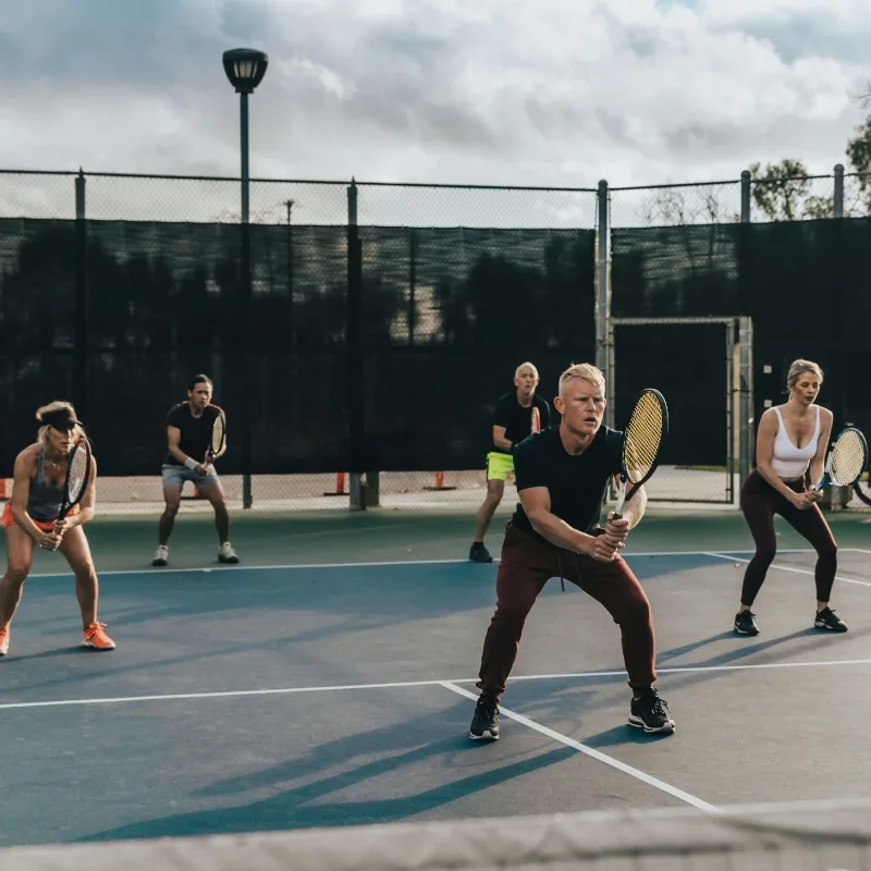Intermediate LiveBall group in ready position under court lights at LBTA