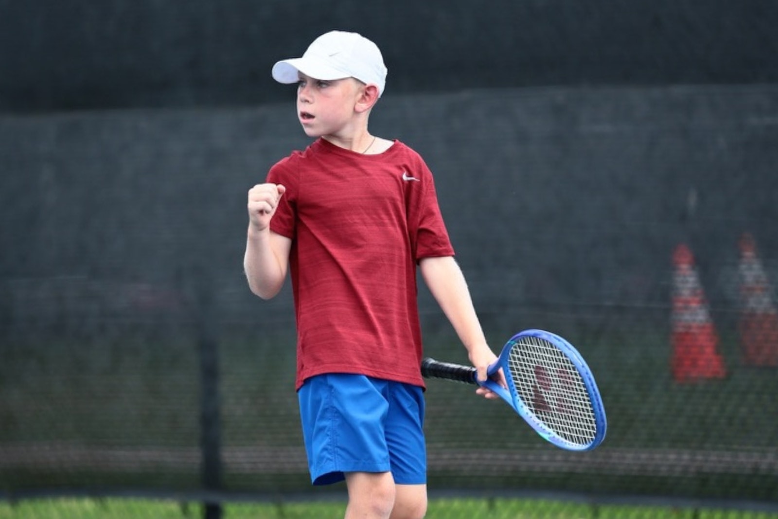 A junior player celebrating a point won at a seasonal-break camp